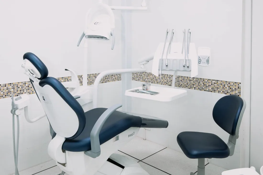 A clean, modern dental operatory — chair, overhead light and delivery unit